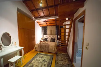 a bedroom with a bed and a staircase in a room at Stone Villa Lagonisi in Lagonissi