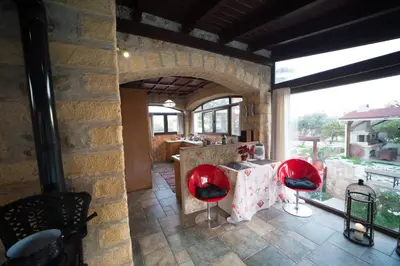 a kitchen with a table and red chairs in a room at Stone Villa Lagonisi in Lagonissi
