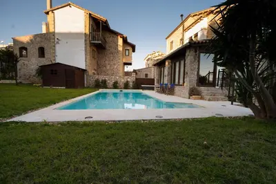 a swimming pool in a yard next to a building at Stone Villa Lagonisi in Lagonissi