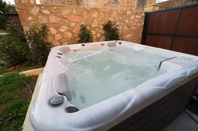 a jacuzzi bathtub in a backyard with at Stone Villa Lagonisi in Lagonissi