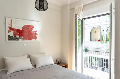 a bedroom with a bed and a large window at Plaka Central in Athens