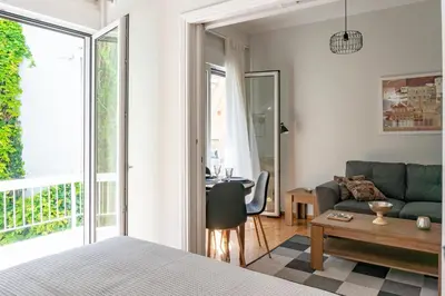 a bedroom with a bed and a living room with a couch at Plaka Central in Athens