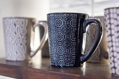 a black coffee mug sitting on a counter with two mugs at Blue Ark Loving Athens in Athens