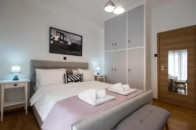 a bedroom with a large white bed with two towels at Blue Ark Loving Athens in Athens