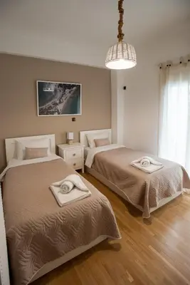 a bedroom with two beds and a chandelier at Blue Ark Loving Athens in Athens