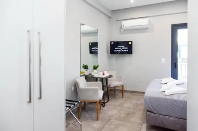 a room with a bed and a table with chairs at D Spacious Brand New Studio Ideal for 2 D in Athens