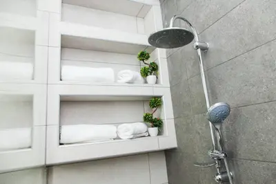 a bathroom with white towels on shelves in a shower at D Spacious Brand New Studio Ideal for 2 D in Athens