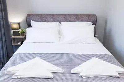 a bed with white sheets and pillows on it at D Spacious Brand New Studio Ideal for 2 D in Athens