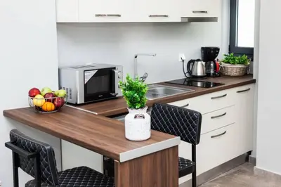 a kitchen with a counter with a sink and a table at Apartments Vouliagmenis Ave 126 in Athens