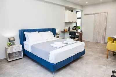 a bedroom with a blue bed and a kitchen at Apartments Vouliagmenis Ave 126 in Athens