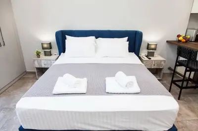 a bed with two white towels on top of it at Apartments Vouliagmenis Ave 126 in Athens