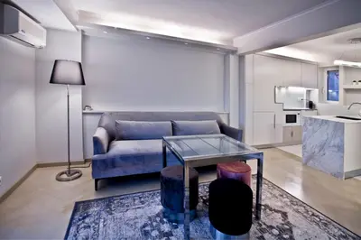 a living room with a blue couch and a table at kolonaki Penthouse panoramic Acropolis view in Athens