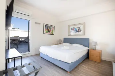 a bedroom with a large bed and a balcony at Downtown Cocoon with Roof Deck in Athens