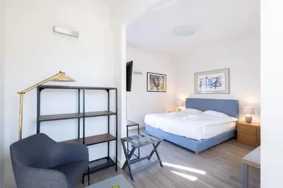 a bedroom with a bed and a chair at Downtown Cocoon with Roof Deck in Athens