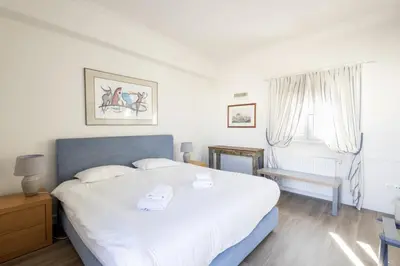 a bedroom with a large white bed and a window at Downtown Cocoon with Roof Deck in Athens