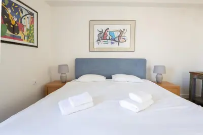 a bedroom with a white bed with two white towels at Downtown Cocoon with Roof Deck in Athens