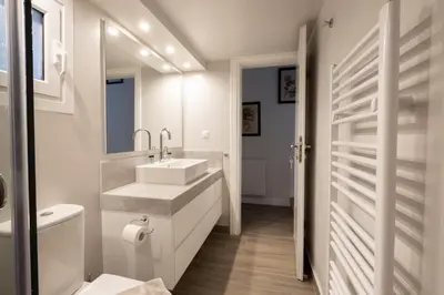 a white bathroom with a sink and a toilet at Historic Plaka's Deluxe Apartment in Athens