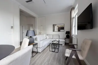 a living room with a white couch and a tv at Historic Plaka's Deluxe Apartment in Athens