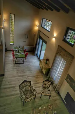 a living room with a table and chairs and windows at Villa Evinoi in Pallíni
