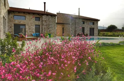 a garden with pink flowers in front of a house at Villa Evinoi in Pallíni