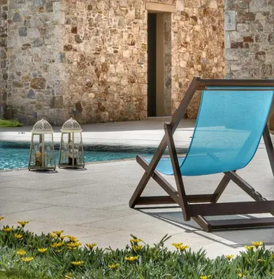 a blue chair sitting next to a swimming pool at Villa Evinoi in Pallíni
