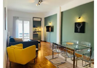 a living room with a yellow chair and a glass table at Cozy Apartment in Central Athens - Sleeps 6 in Athens