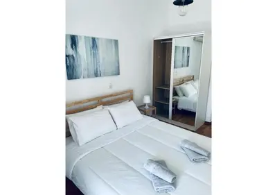 a bedroom with a large white bed with a mirror at Cozy Apartment in Central Athens - Sleeps 6 in Athens