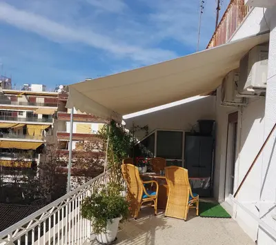 a balcony with chairs and a table on a building at Dream apartment in Athens