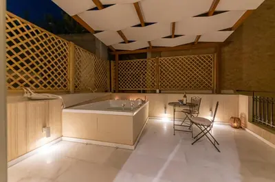 a bathroom with a tub and a table and chairs at IPELHOME - Plaka Boutique Apartments in Athens