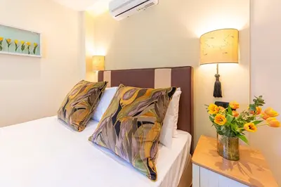 a bedroom with a bed with a vase of flowers on a table at IPELHOME - Plaka Boutique Apartments in Athens