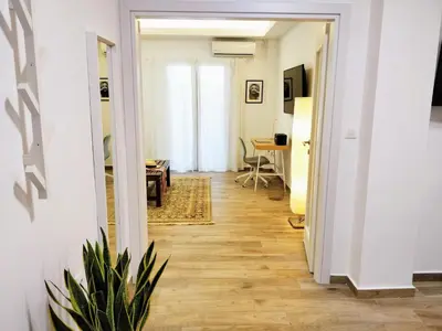 a hallway leading to a living room with a table at The Countess Riencourt Apartment in Athens