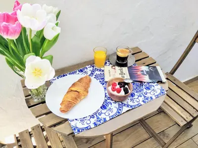 a breakfast table with a plate of food and flowers at The Countess Riencourt Apartment in Athens