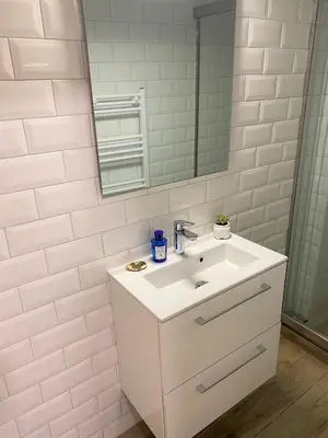 a white bathroom with a sink and a mirror at The Countess Riencourt Apartment in Athens