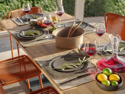 a wooden table with plates and glasses of wine at 3 Olive Trees in Anavissos