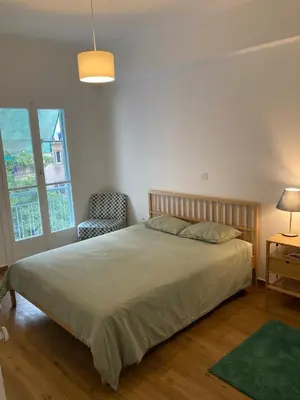 a bedroom with a bed and a chair and a window at Great Apartment with Terrace in Central Athens in Athens