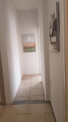 a hallway with a white wall and a painting on the wall at Sky Apartment - Athens Center, 5 BD, 4 BATH in Athens