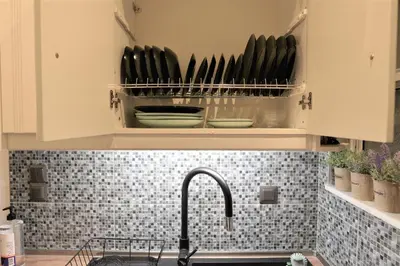 a kitchen with a sink and a counter top with dishes at Cozy Apt in Ilisia with Urban Forest View in Athens