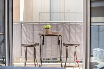 a table with two chairs and a potted plant on a balcony at Athens F&K Boutique Apartment in Athens