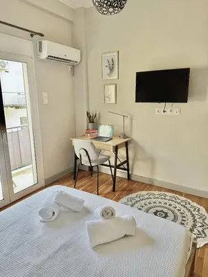 a bedroom with a bed and a desk with a laptop at Athens F&K Boutique Apartment in Athens