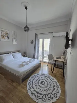 a bedroom with a large bed and a television at Athens F&K Boutique Apartment in Athens