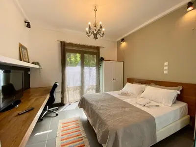 a bedroom with a bed and a desk and a chandelier at Small Gem Studio Athens, next to metro nomismatokopeio in Athens