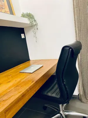 a desk with a laptop and a black chair at Small Gem Studio Athens, next to metro nomismatokopeio in Athens