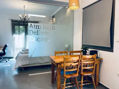 a table and chairs in a room with a bed at Small Gem Studio Athens, next to metro nomismatokopeio in Athens