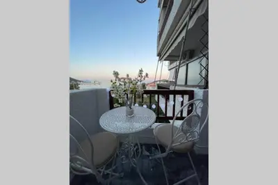 a table and chairs on the balcony of a building at RUSTIC DIAMOND new apartment near the beach in Porto Rafti
