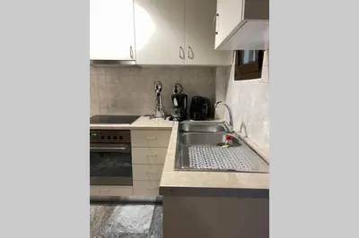 a kitchen with white cabinets and a sink at RUSTIC DIAMOND new apartment near the beach in Porto Rafti