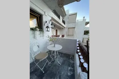 a room with a table and chairs on a balcony at RUSTIC DIAMOND new apartment near the beach in Porto Rafti