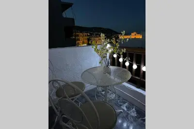 a table and chairs on a balcony at night at RUSTIC DIAMOND new apartment near the beach in Porto Rafti