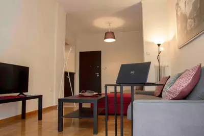 a living room with a couch and a laptop on a table at 7 Steps Apartment Metro Syggrou Fix near Acropolis in Athens