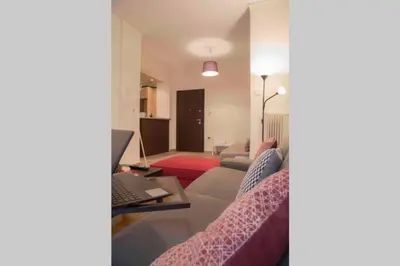 a living room with a couch and a laptop at 7 Steps Apartment Metro Syggrou Fix near Acropolis in Athens