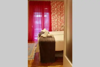 a bedroom with a bed with pink curtains and a window at 7 Steps Apartment Metro Syggrou Fix near Acropolis in Athens